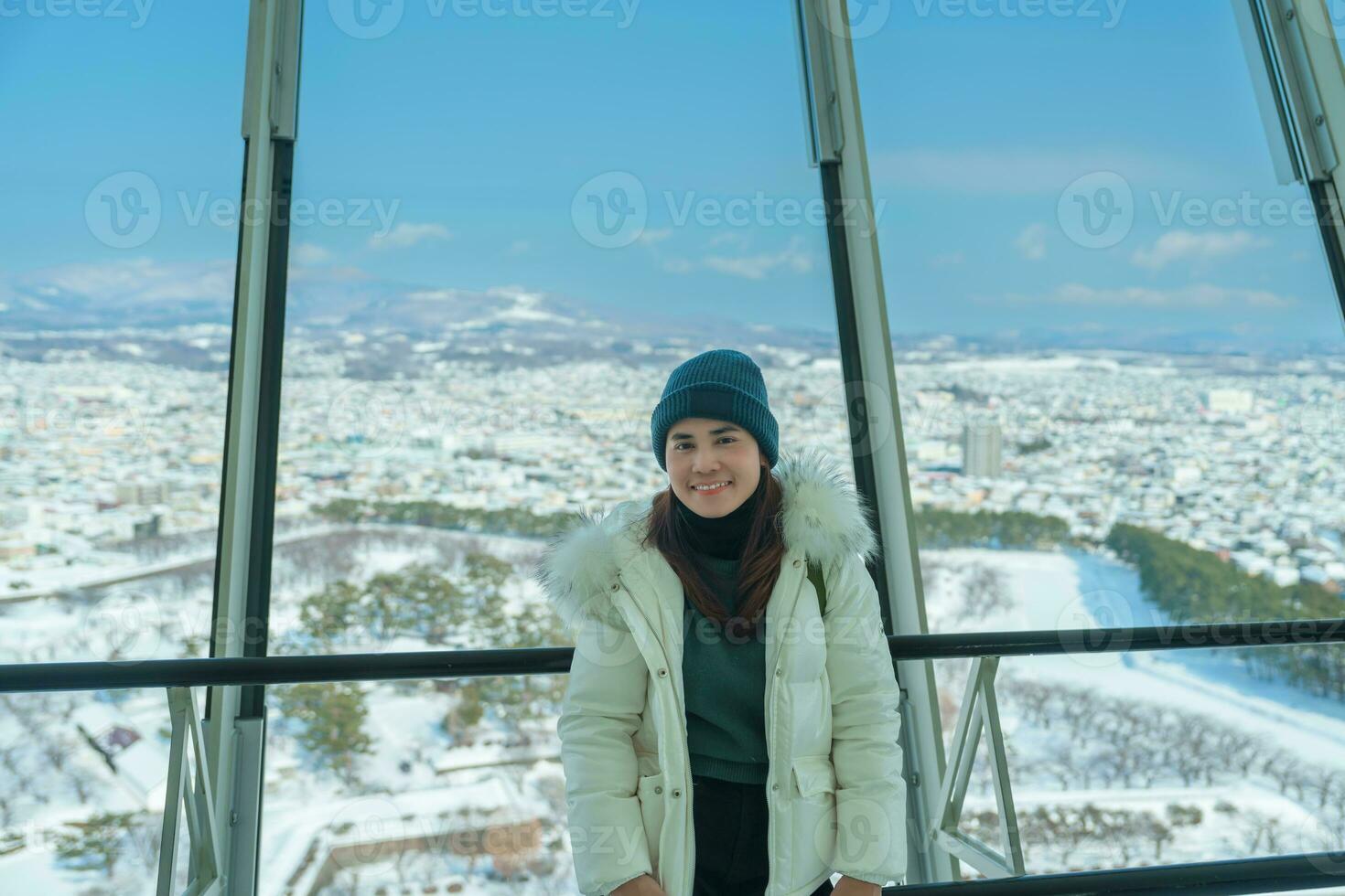 Woman tourist Visiting in Hakodate, Traveler in Sweater sightseeing view from Goryokaku Tower with Snow in winter. landmark and popular for attractions in Hokkaido, Japan.Travel and Vacation concept photo