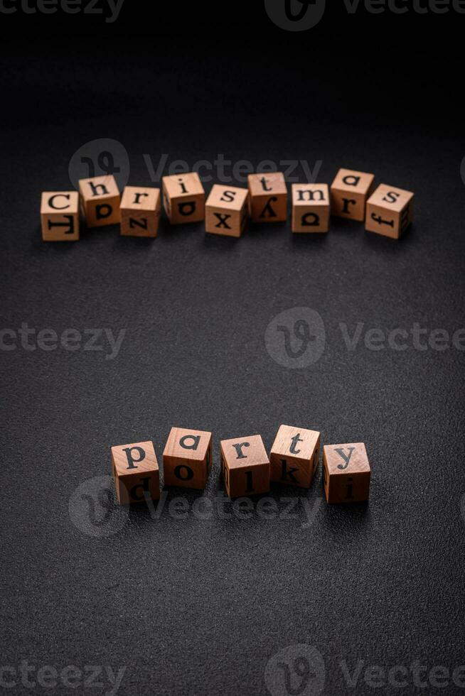 Christmas party inscription with wooden cubes on a dark concrete background photo