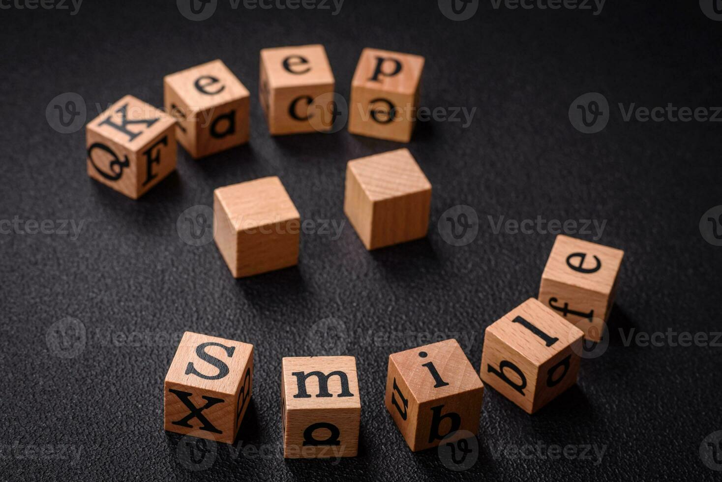 A concept consisting of the inscription of the word smile, with round emoticons on a dark concrete background photo