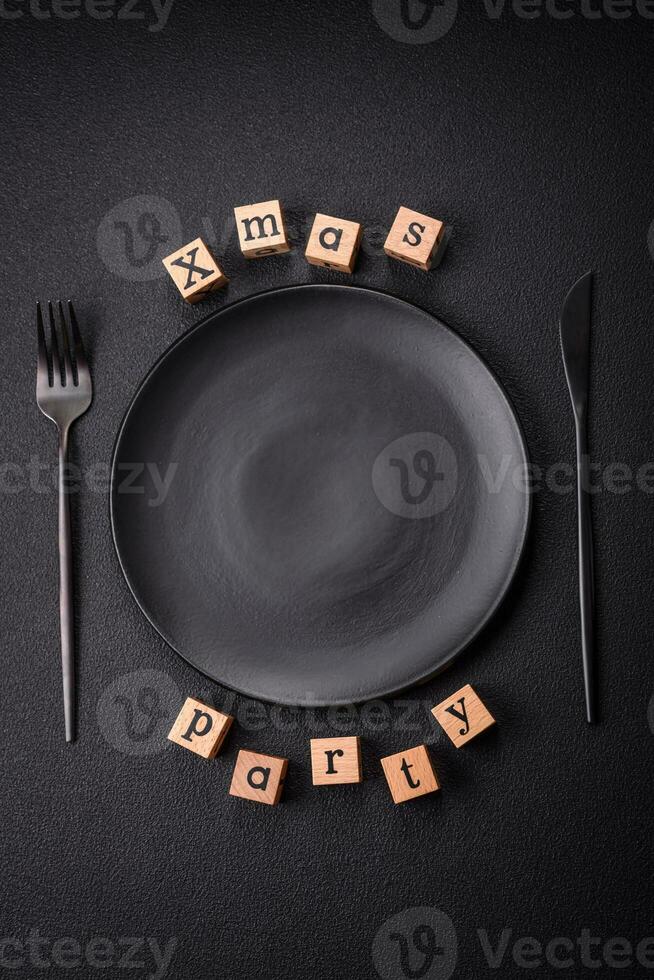 Christmas party inscription with wooden cubes on a dark concrete background photo