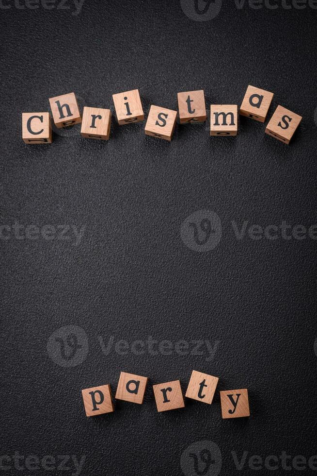 Christmas party inscription with wooden cubes on a dark concrete background photo