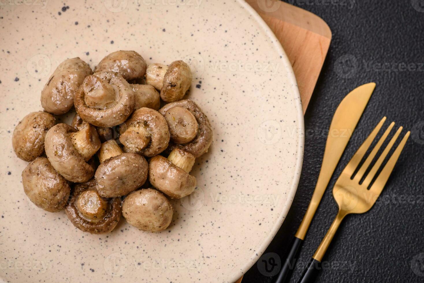 Delicious juicy whole champignons baked on the grill with salt and spices photo