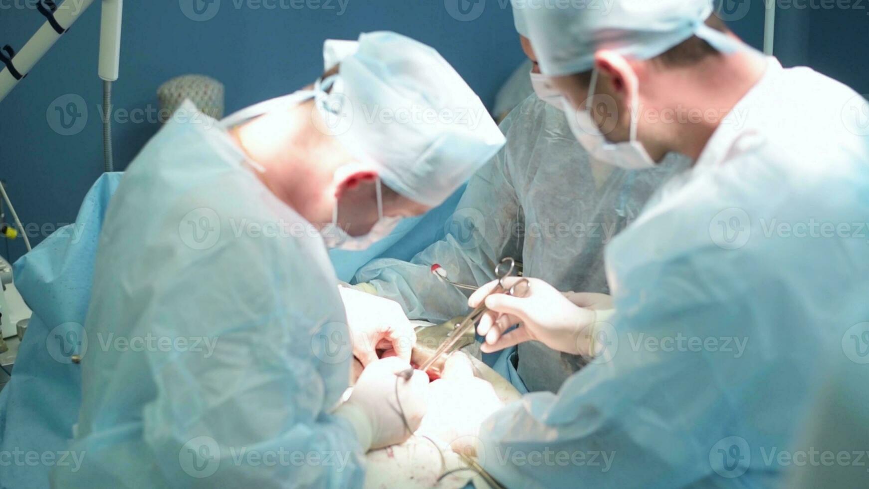 A highly qualified team of surgeons performs a complex operation to remove a pancreatic cyst using medical instruments photo