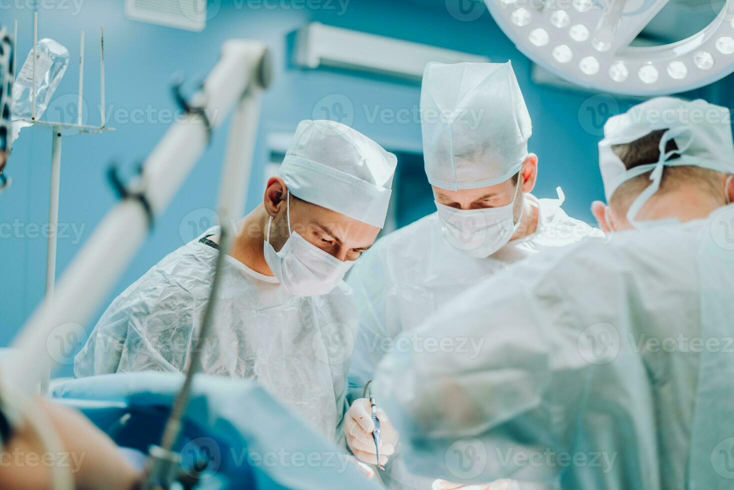 A highly qualified team of surgeons performs a complex operation to remove a pancreatic cyst using medical instruments photo