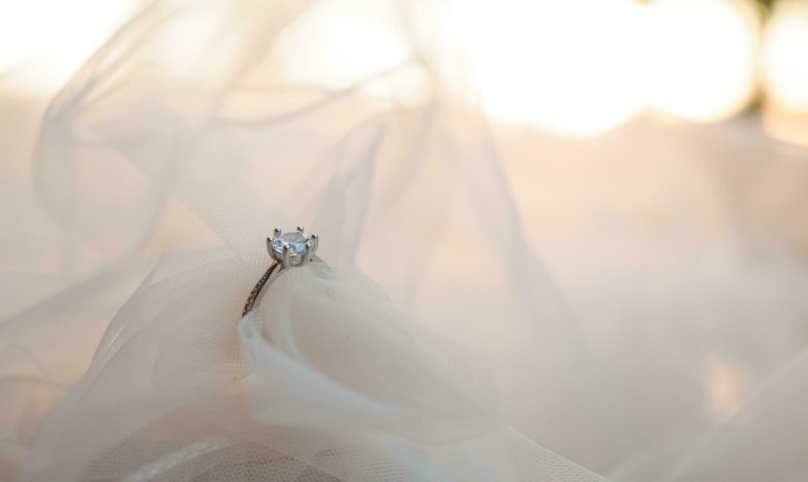 Diamond engagement wedding rings on bridal veil. Wedding accessories, Valentine's day and Wedding day concept. photo