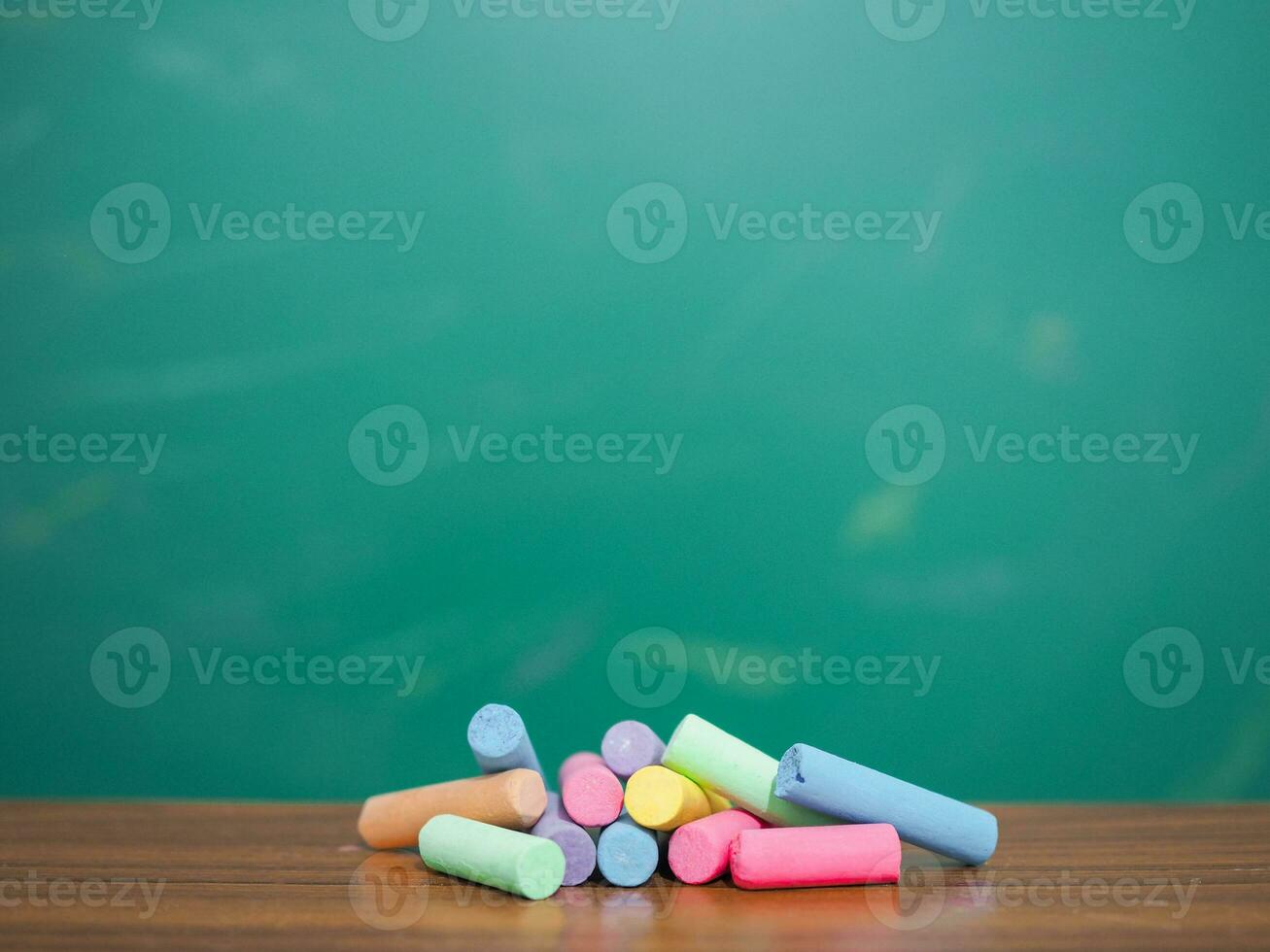 Multicolor chalk on wooden with backboard for education background photo