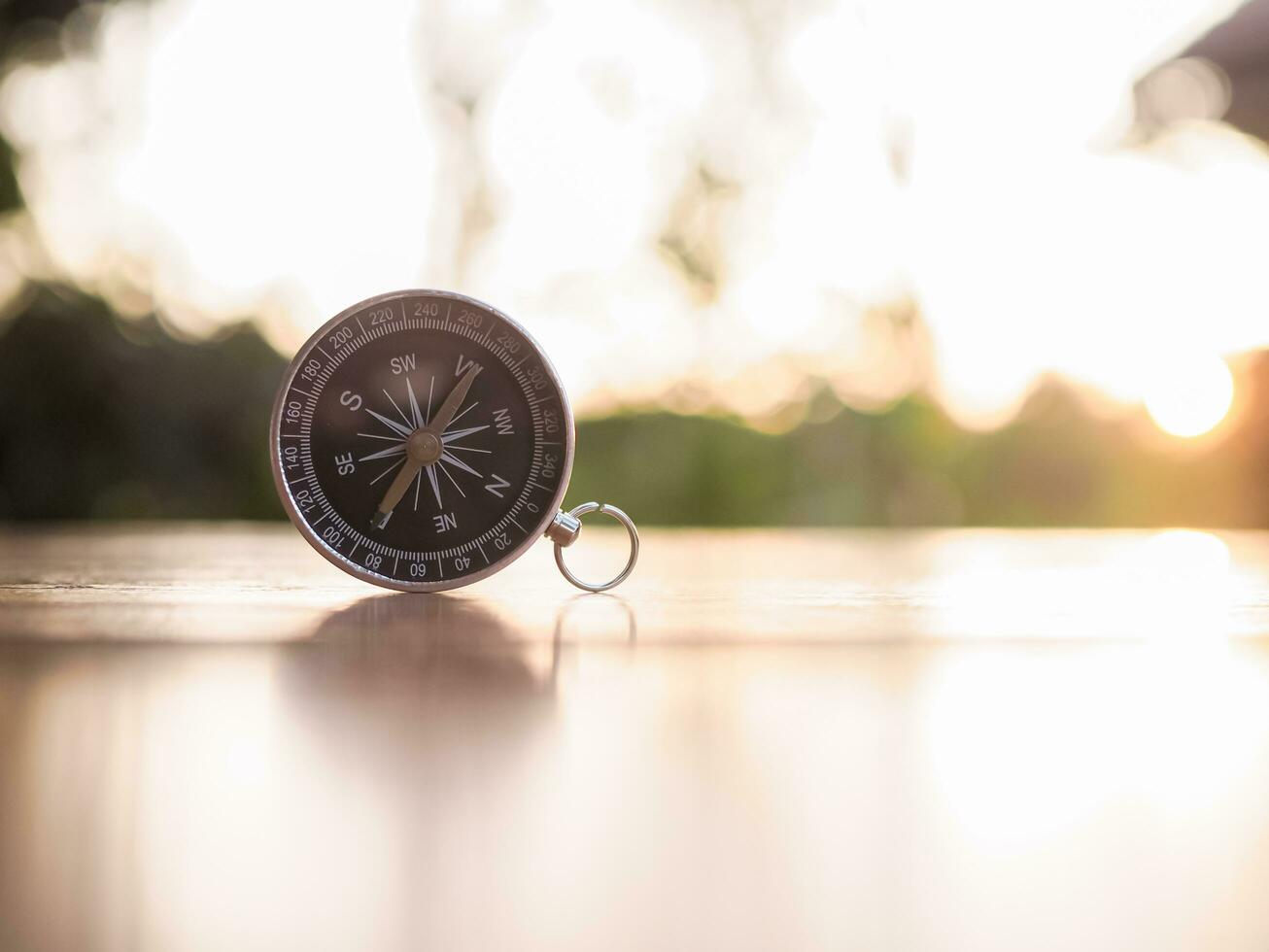 Close up compass on table in the sunset time. The concept of world tourism day, Searching the right directions and Travel photo