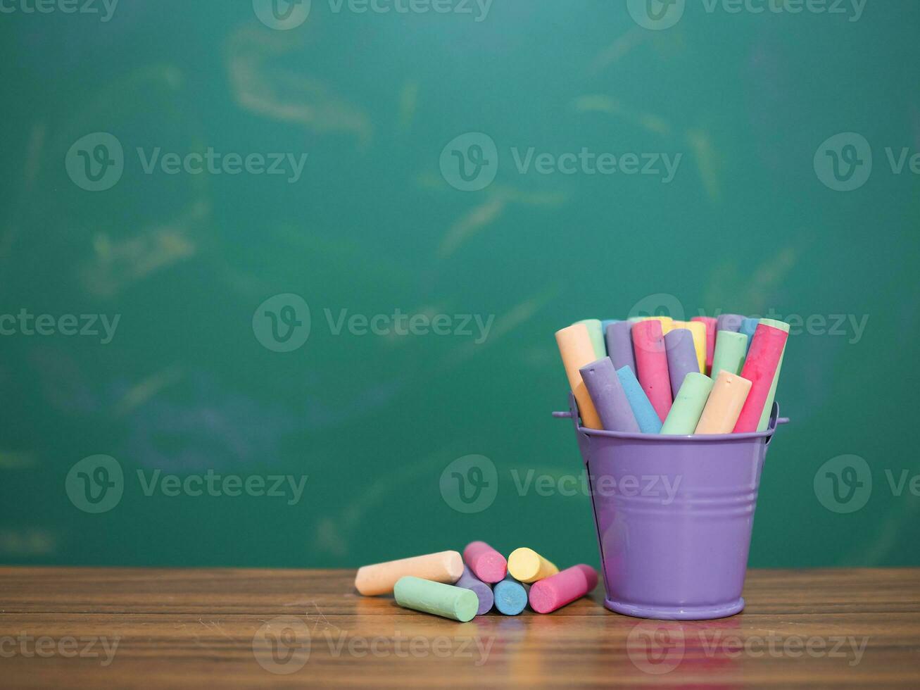 Multicolor chalk on wooden with backboard for education background photo