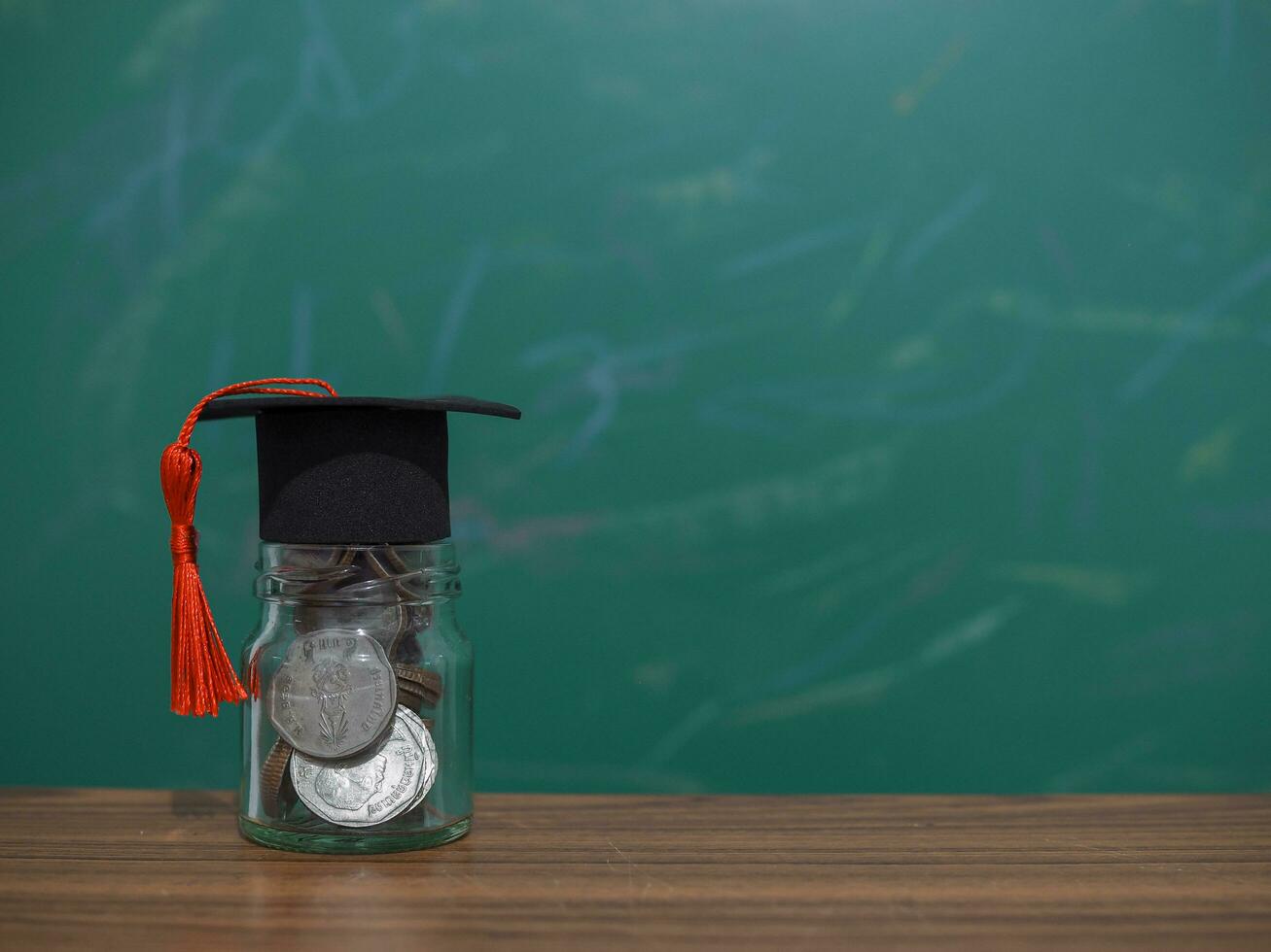 Close up money in the glass bottle with graduation hat. The concept of saving money for education, student loan, scholarship, tuition fees in future photo