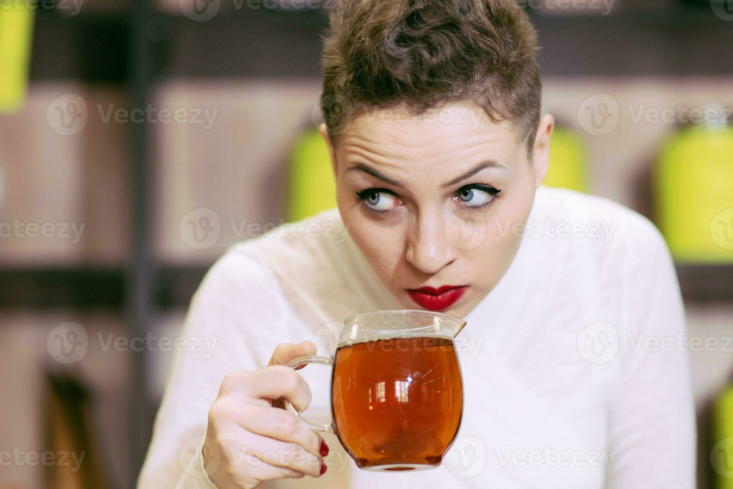 Beautiful girl drinks green tea in coffee photo