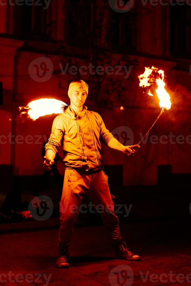 The guy on the street performs with fire torches photo