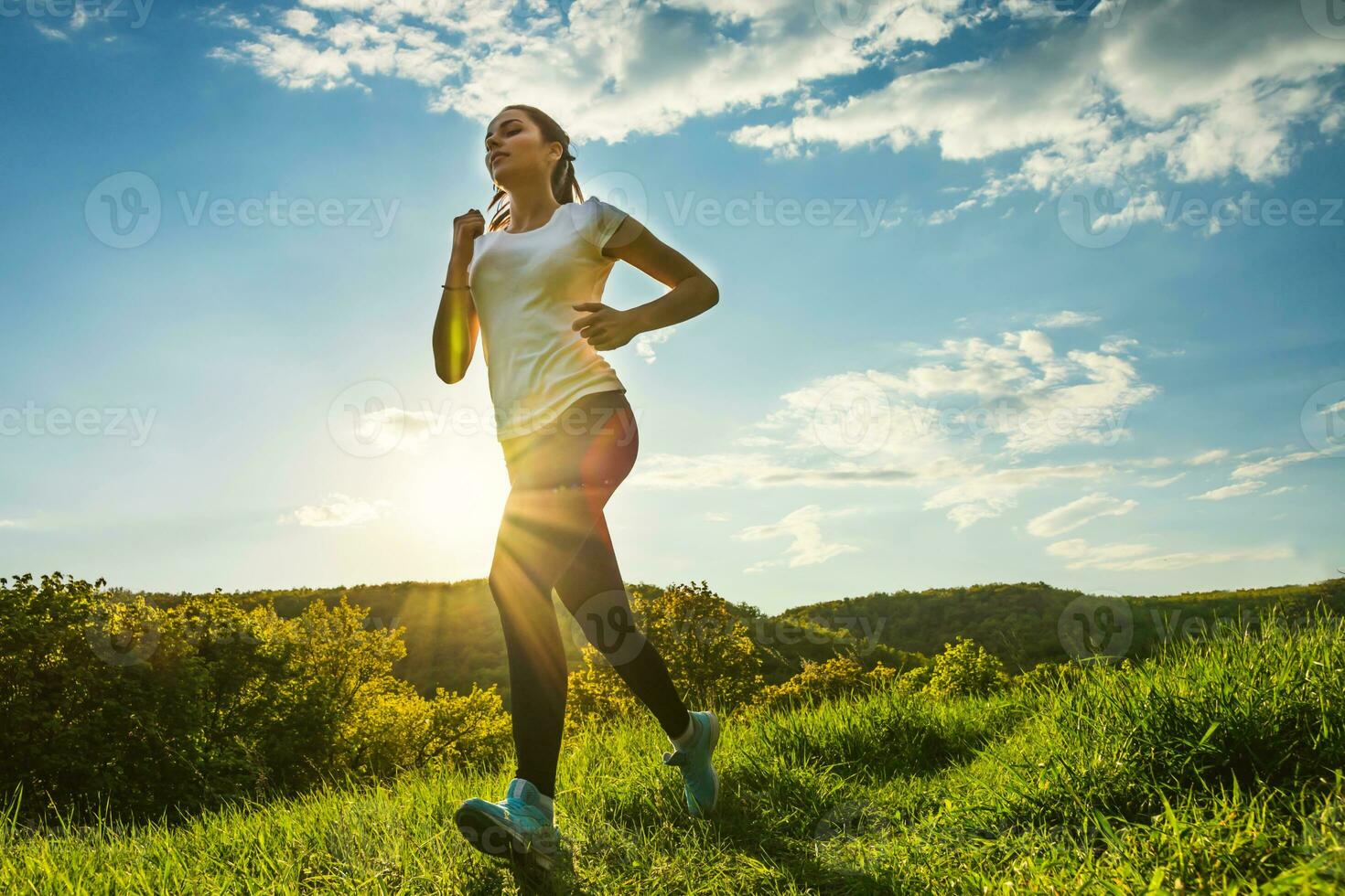 sports girl runs cross-country at sunset in spring photo