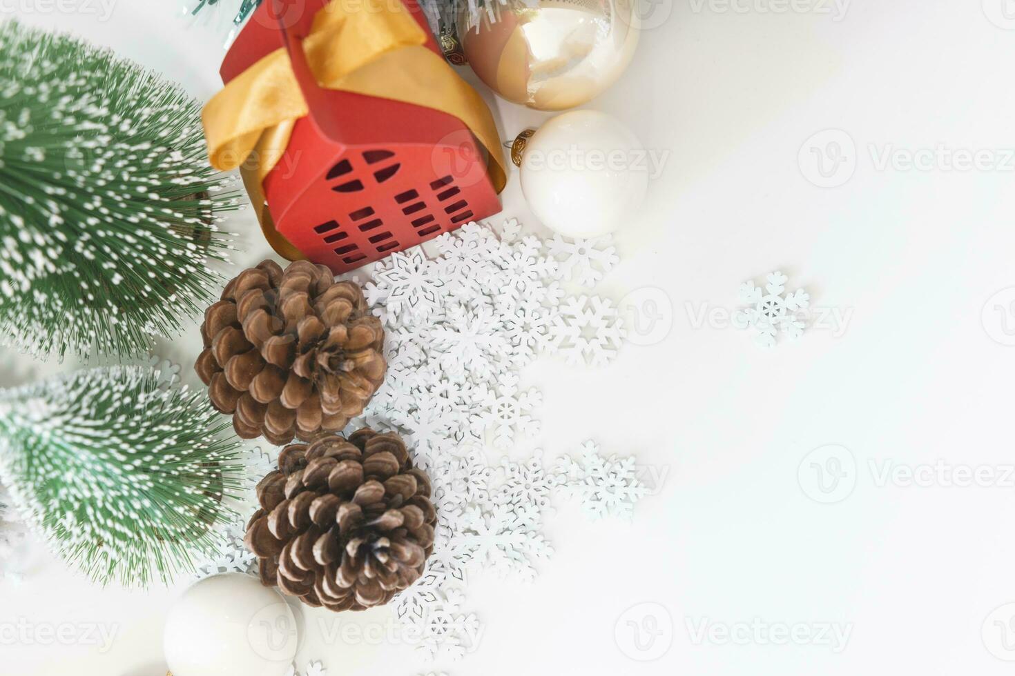 Top view festive scene is a beautiful Christmas tree adorned, with Christmas balls, pine cones, and a red house gift box tied with golden ribbon. Christmas mockup with space for text. photo