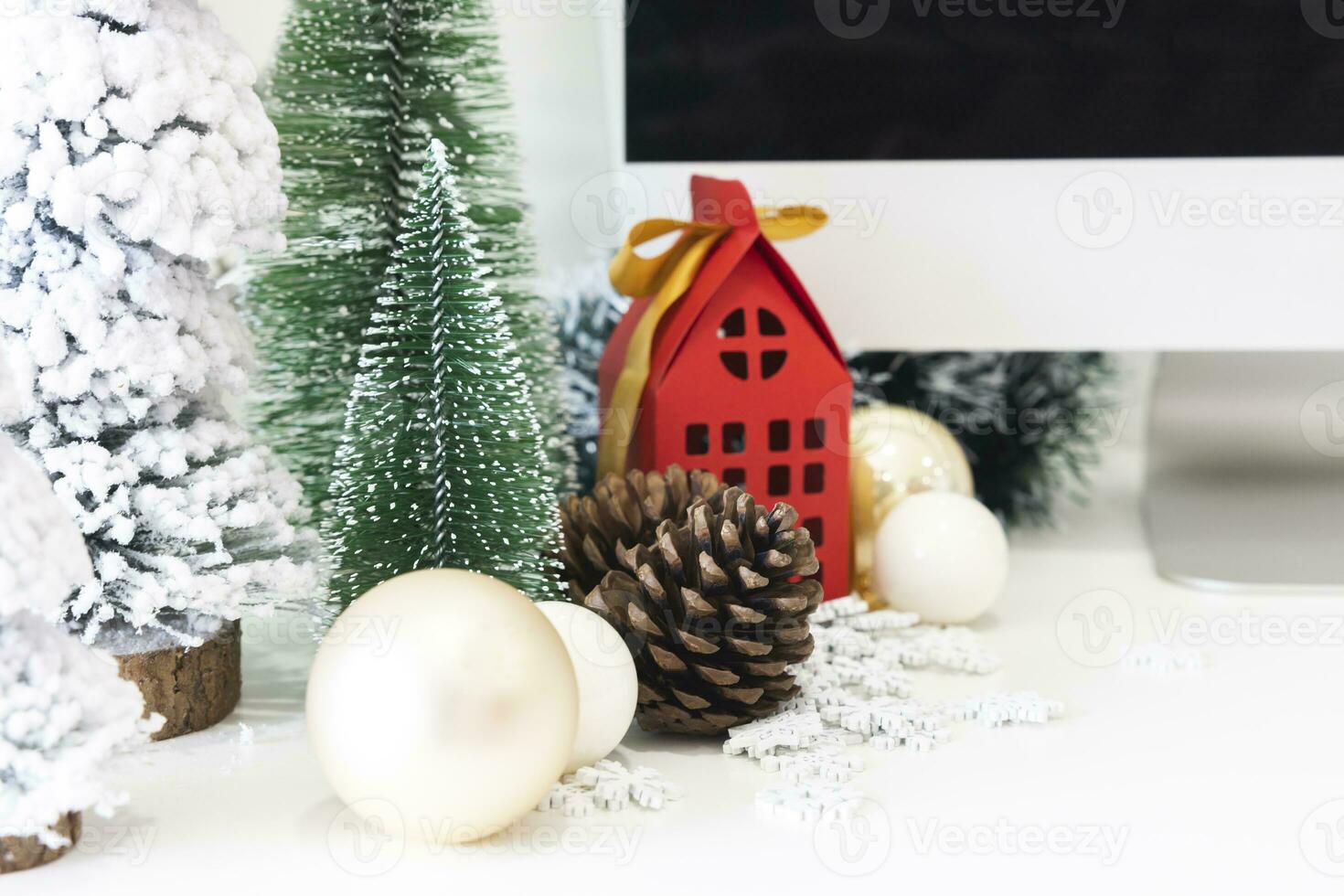 Festive scene is a beautiful Christmas tree adorned, with Christmas balls, pine cones, and a red house gift box tied with golden ribbon. Christmas mockup with space for text. photo