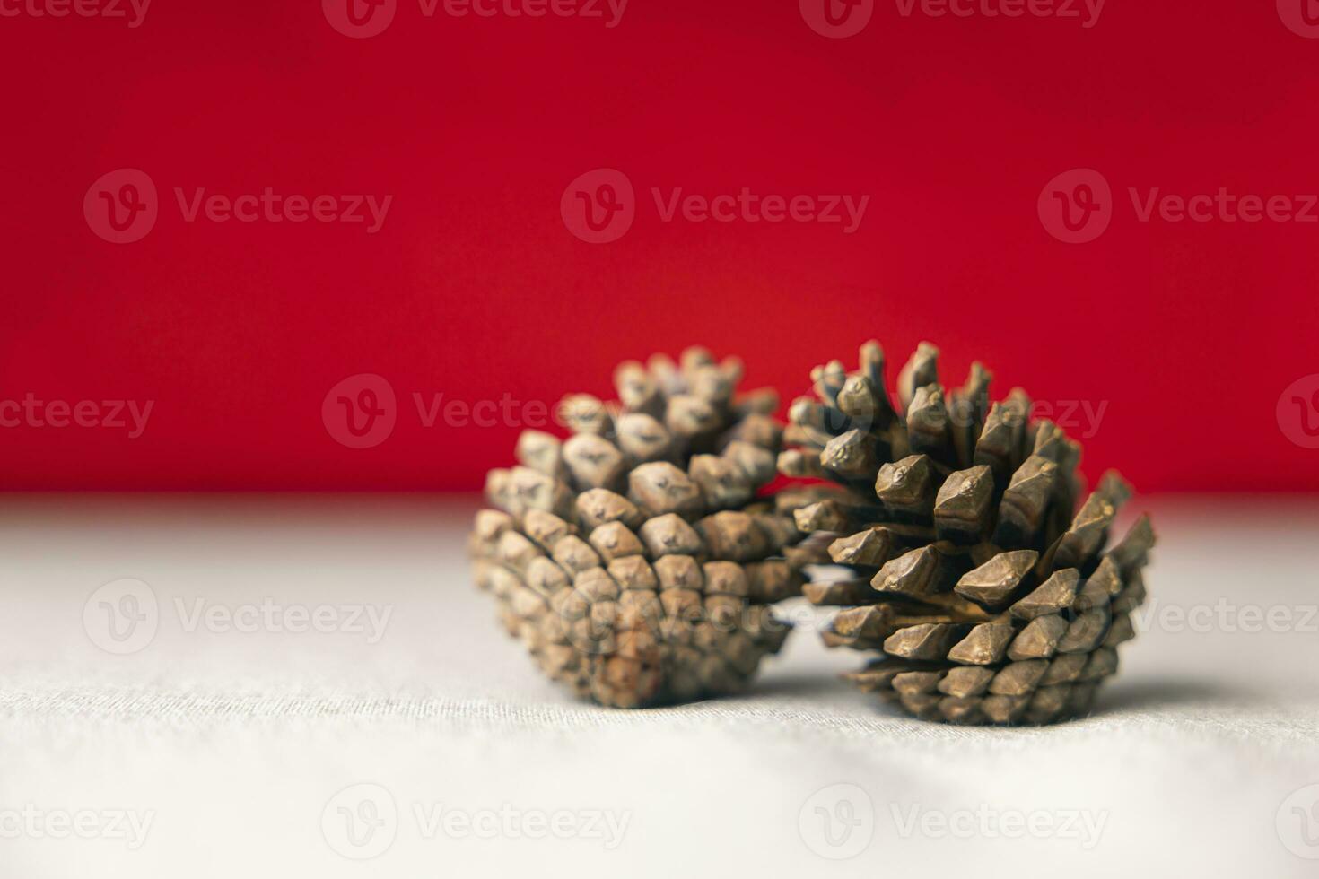 Festive Joy Two Pine cones on a Cream-Colored Cloth, Set Against a Red Background. Capturing the New Year Celebration Atmosphere, about of Important day, Relaxation, New Year's, Christmas. photo