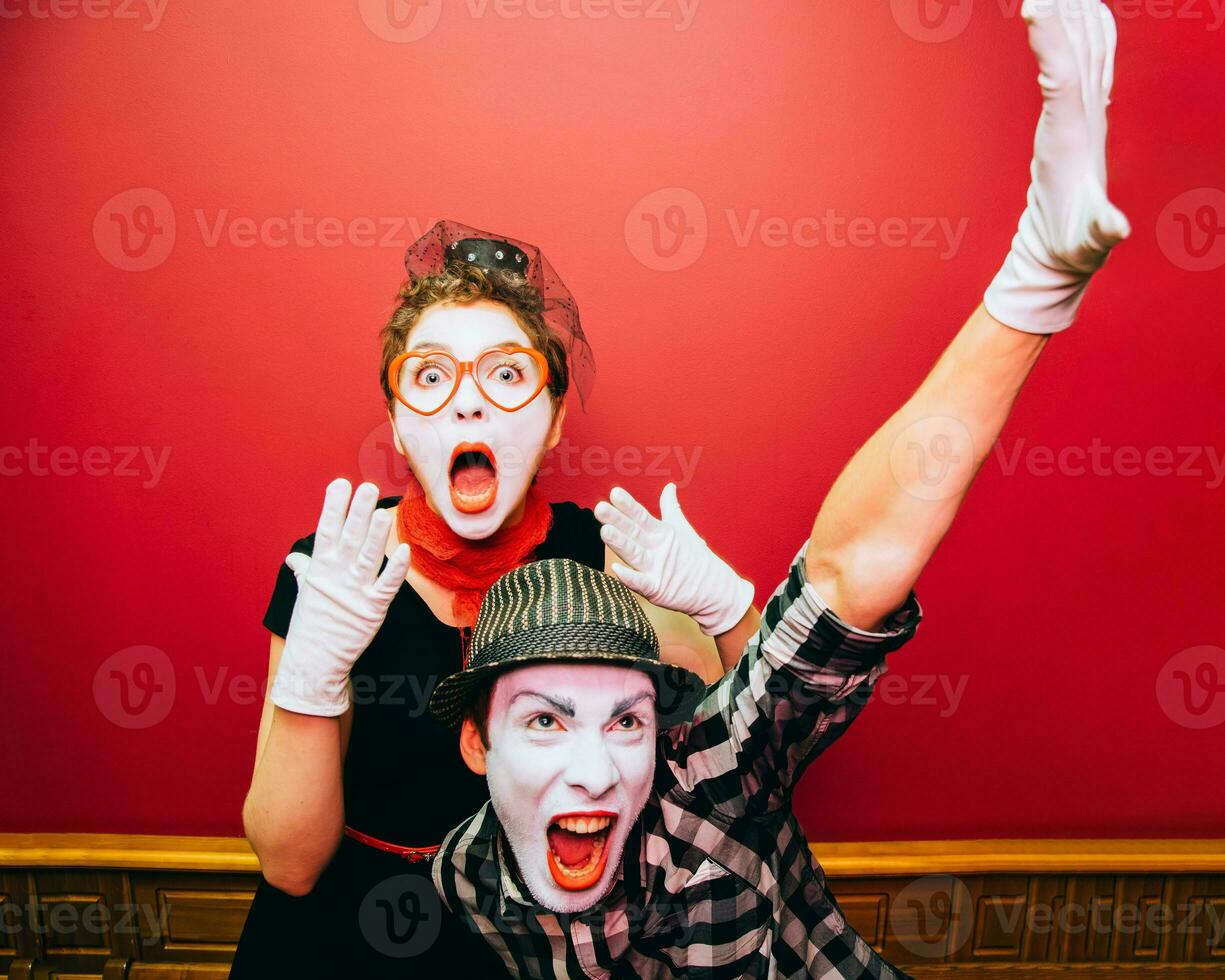 two mimes posing against a red wall background photo