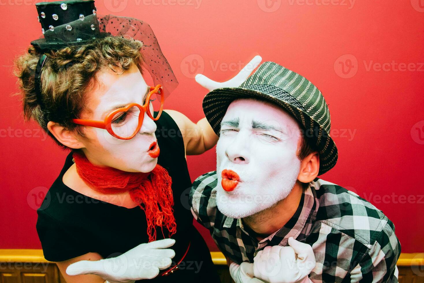 two mimes posing against a red wall background photo