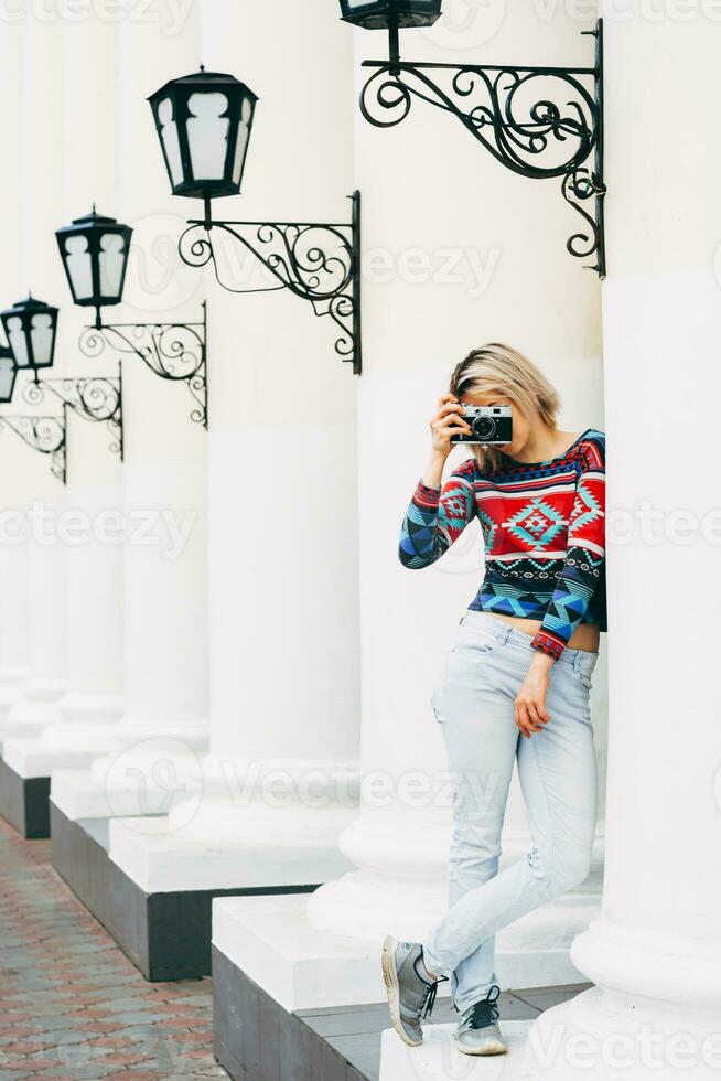 Woman photographed retro camera in the city photo