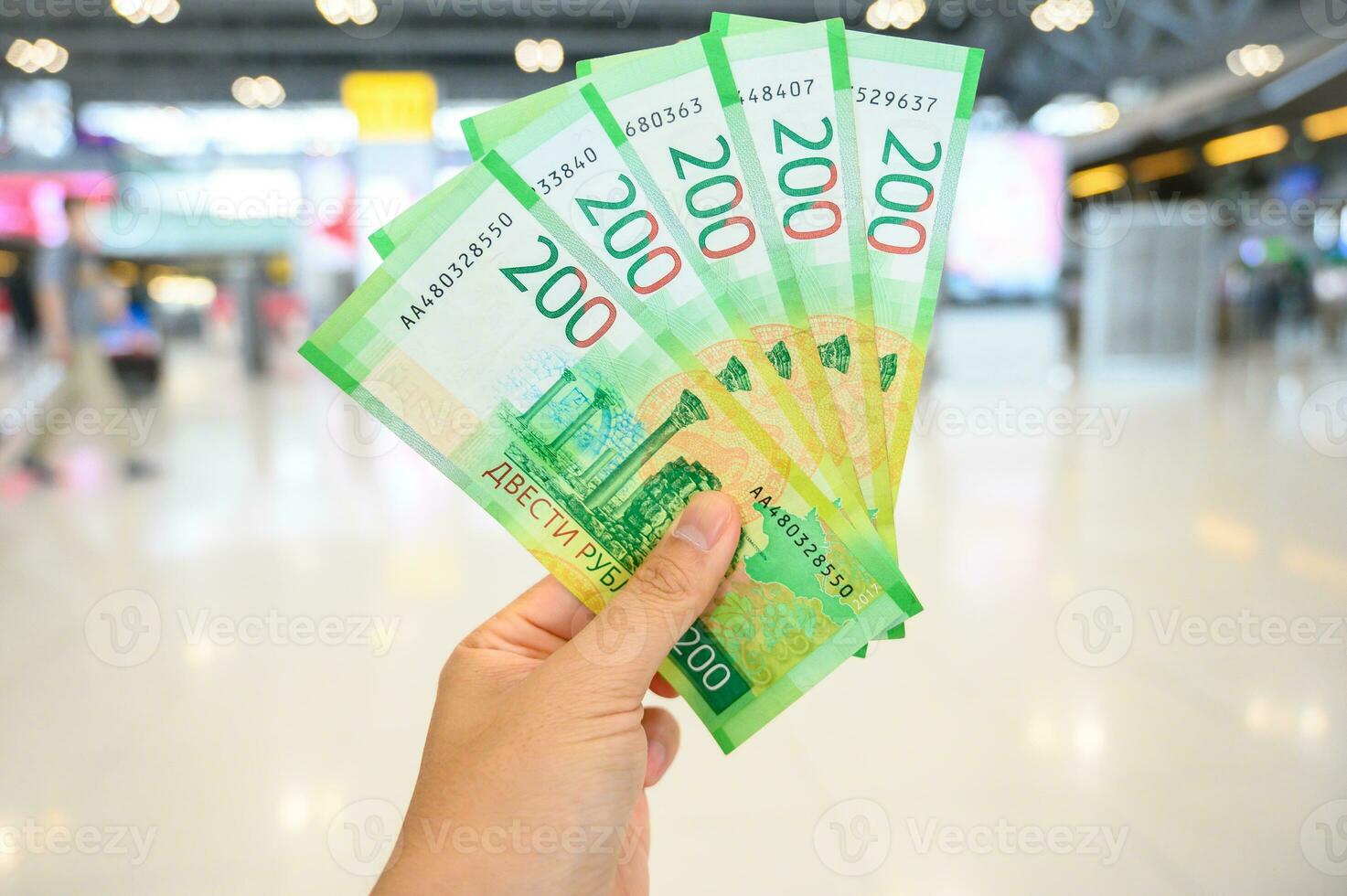 Close-up of someone holding and showing group of 200rub Russian banknotes in the hand. The Russian ruble is the currency of the Russian Federation. photo