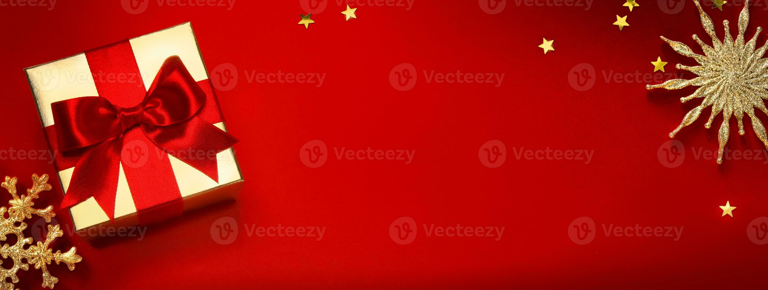 Christmas banner or greeting card background with christmas gift box and golden decoration on red background photo