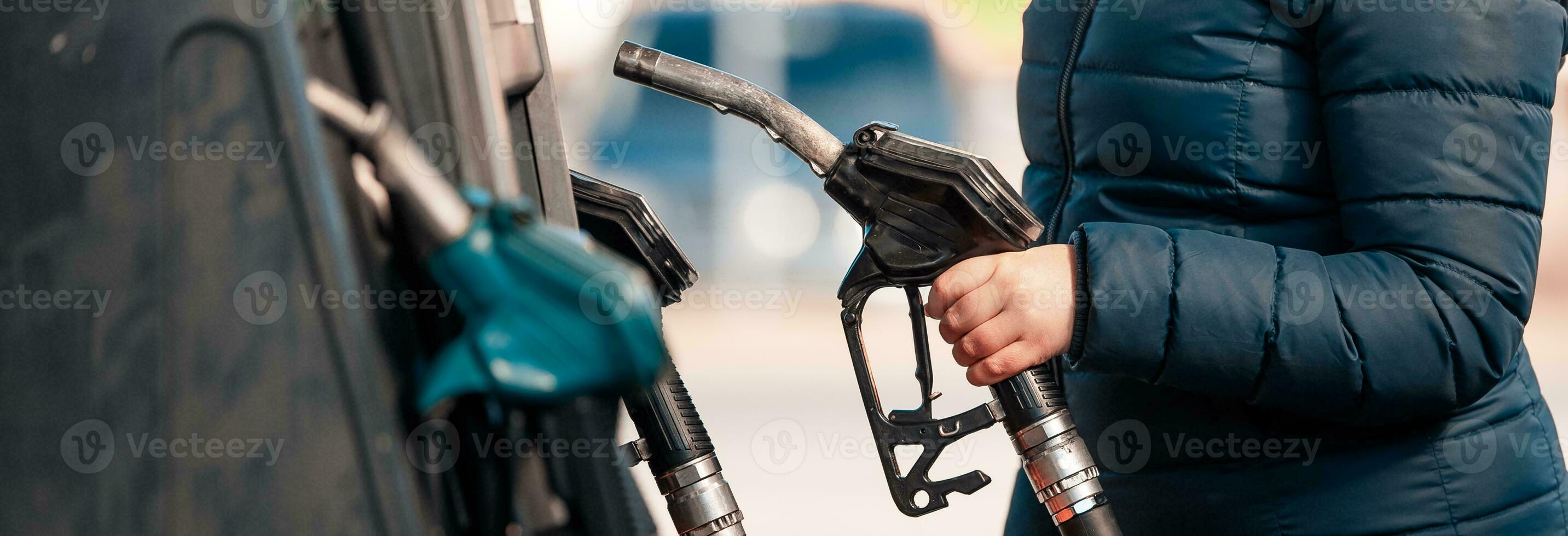 High prices of petrol and diesel fuel ath the petrol station, young woman refueling the car, economic crisis concept photo