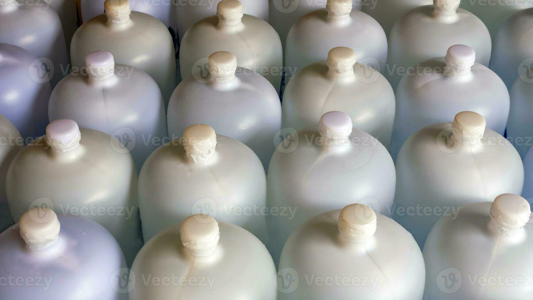 lined up plastic big bottles  or white gallons of purified drinking water inside the production line. Water drink factory photo