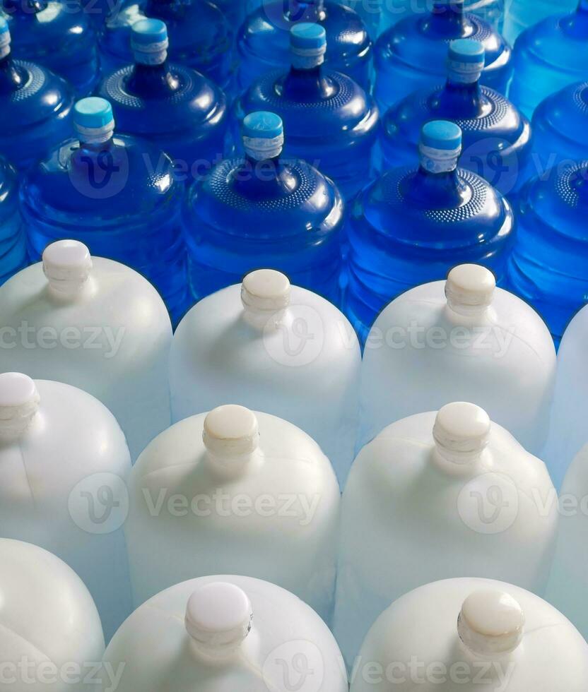 Top view of plastic big bottles or white and blue gallons of purified drinking water inside the production line. Water drink factory photo