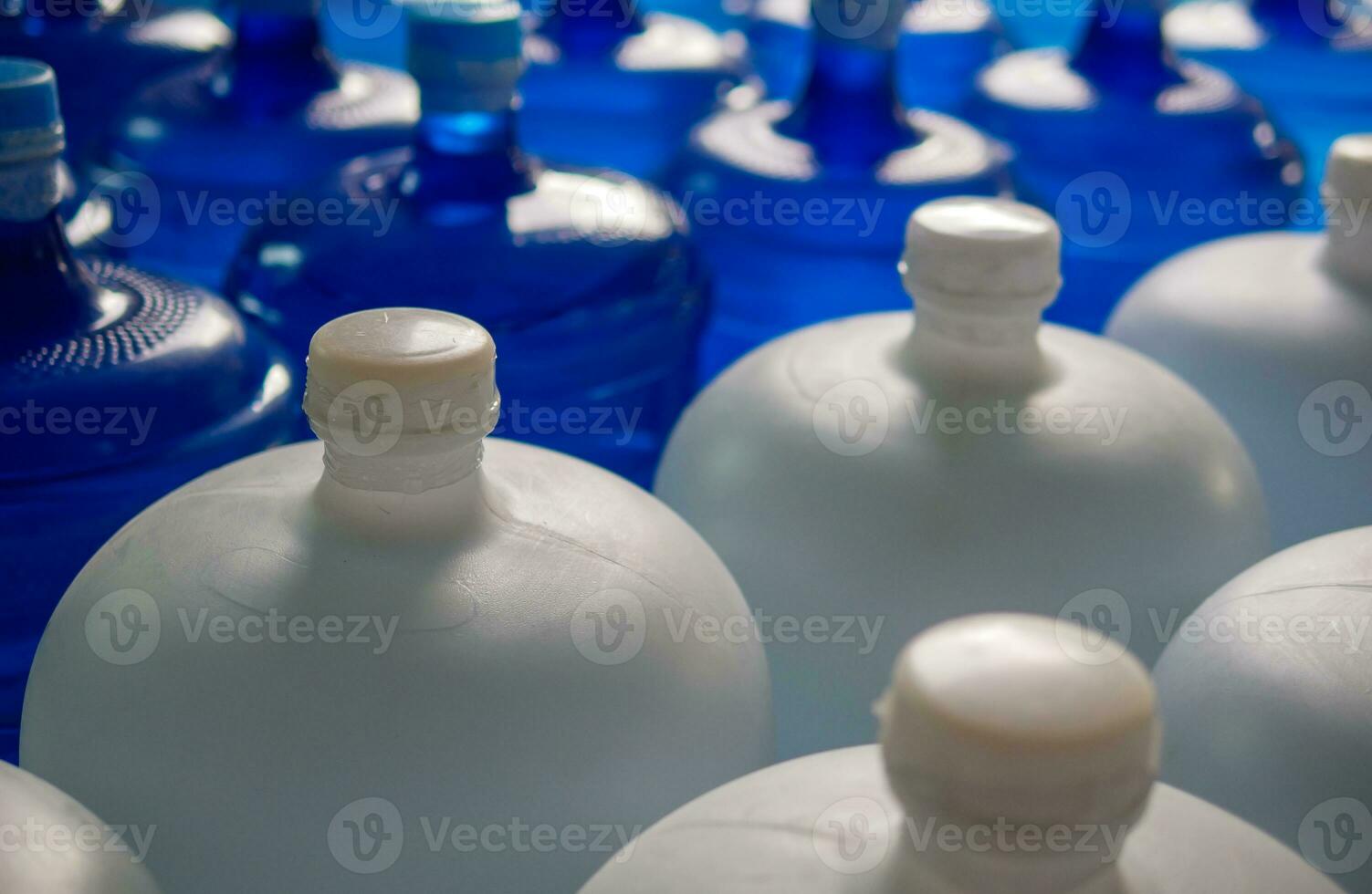 plastic big bottles or white and blue gallons of purified drinking water inside the production line. Water drink factory photo