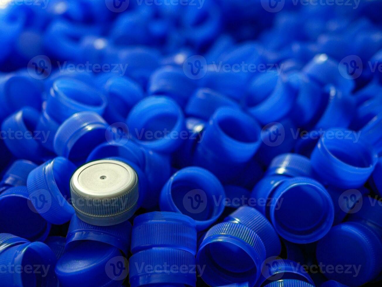 Grey plastic bottle caps on top to depict the concept of standing out from the crowd, dare to be different, odd man out, success or a leadership concept. photo