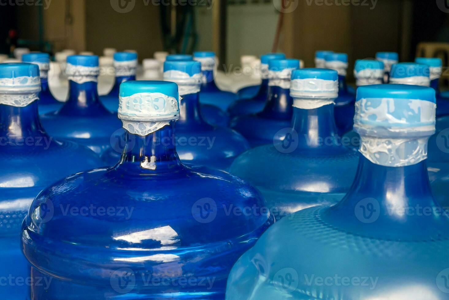 lined up plastic big bottles  or blue gallons of purified drinking water inside the production line. Water drink factory photo