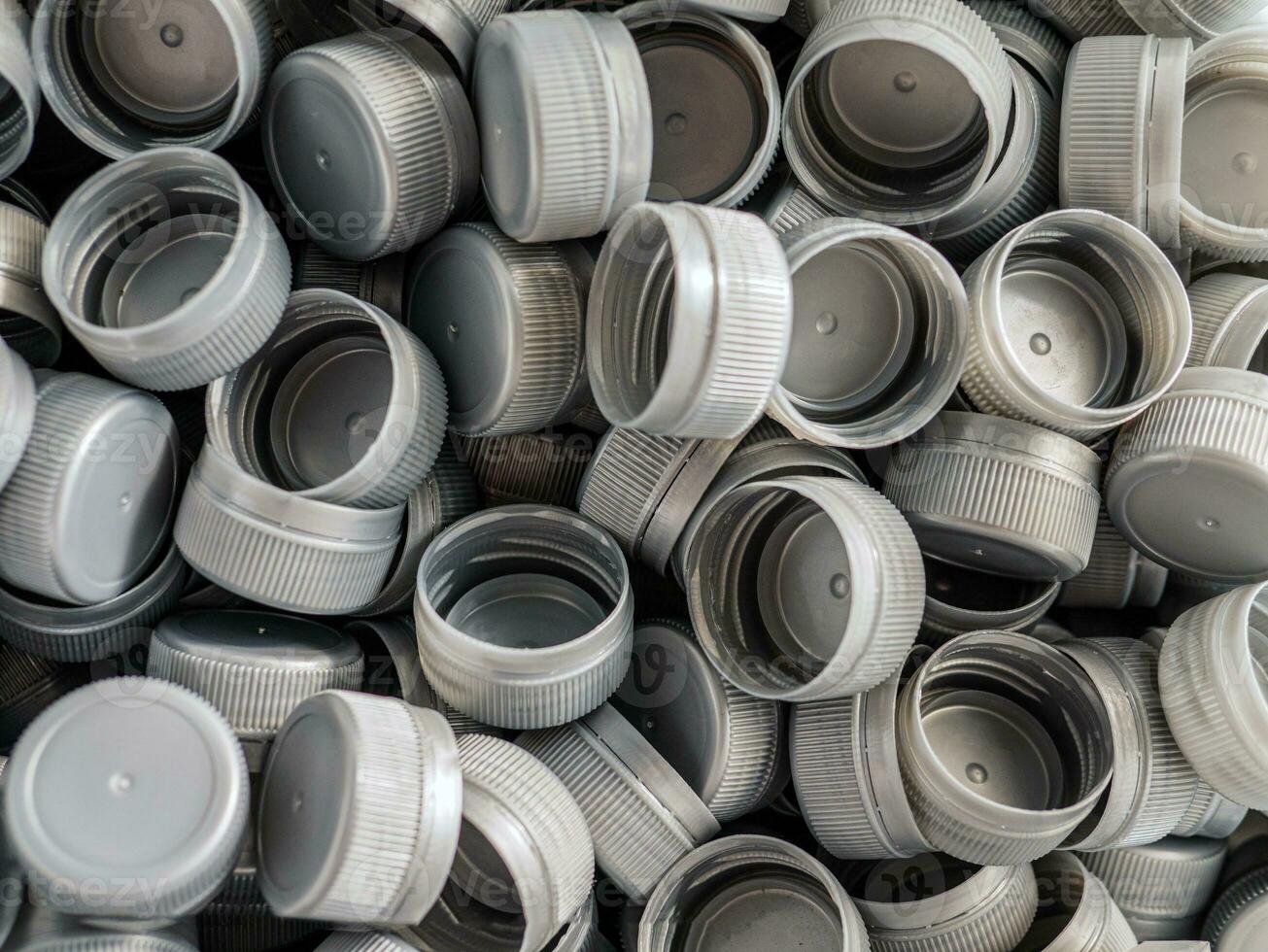 Top view grey plastic bottle caps.Recycling collection and production processing plastic bottle caps background photo