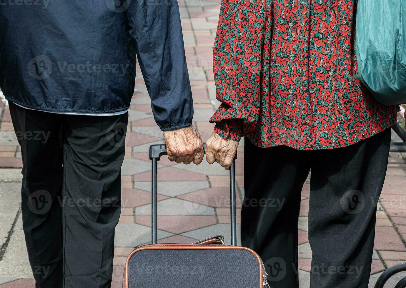 Back view grandparents dragging a suitcase photo