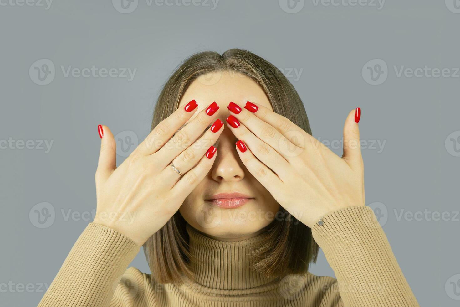 See nothing concept. Woman covers her eyes with her hands. photo