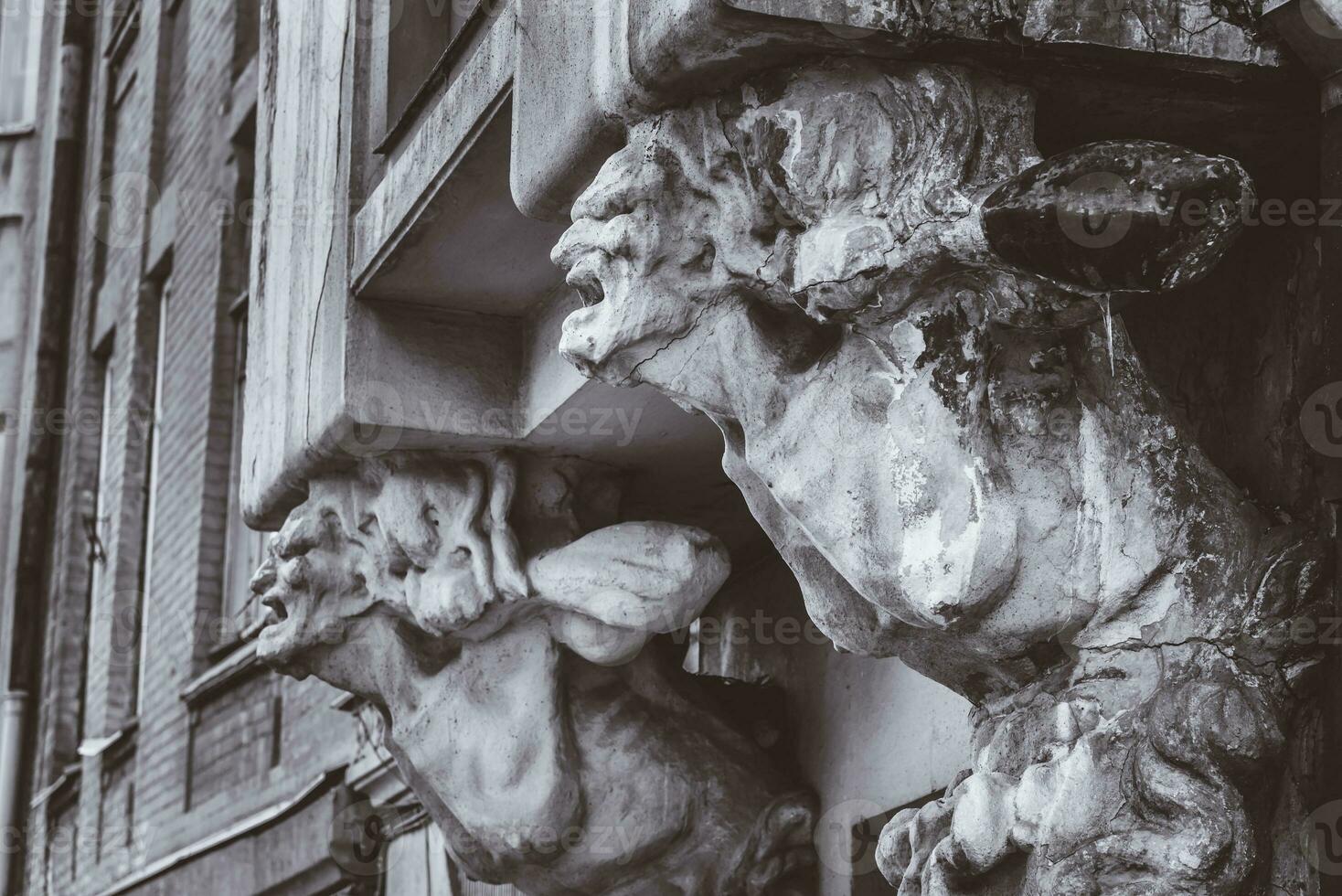 bust of concrete of a terrible woman on the facade of an old house photo