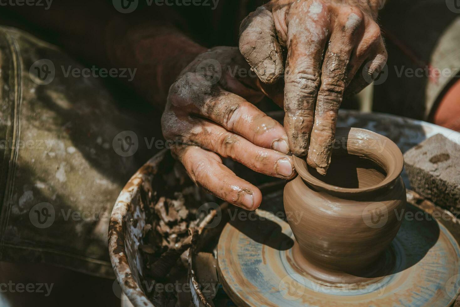 Master hands makes a pot of clay. Master class is held in nature, close-up photo