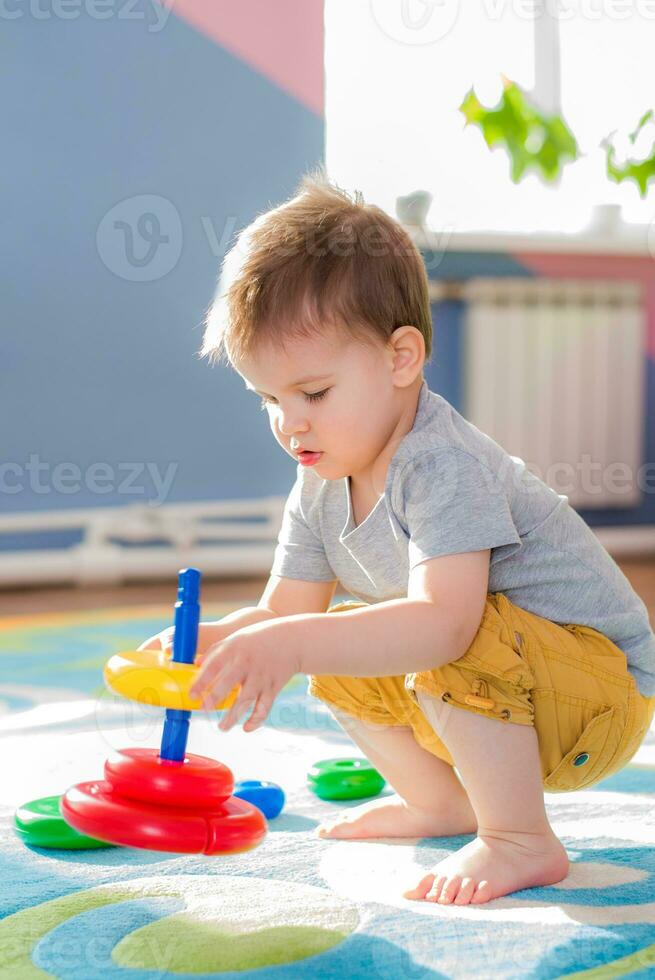 the little kid collects a piraimda sitting on a floor photo