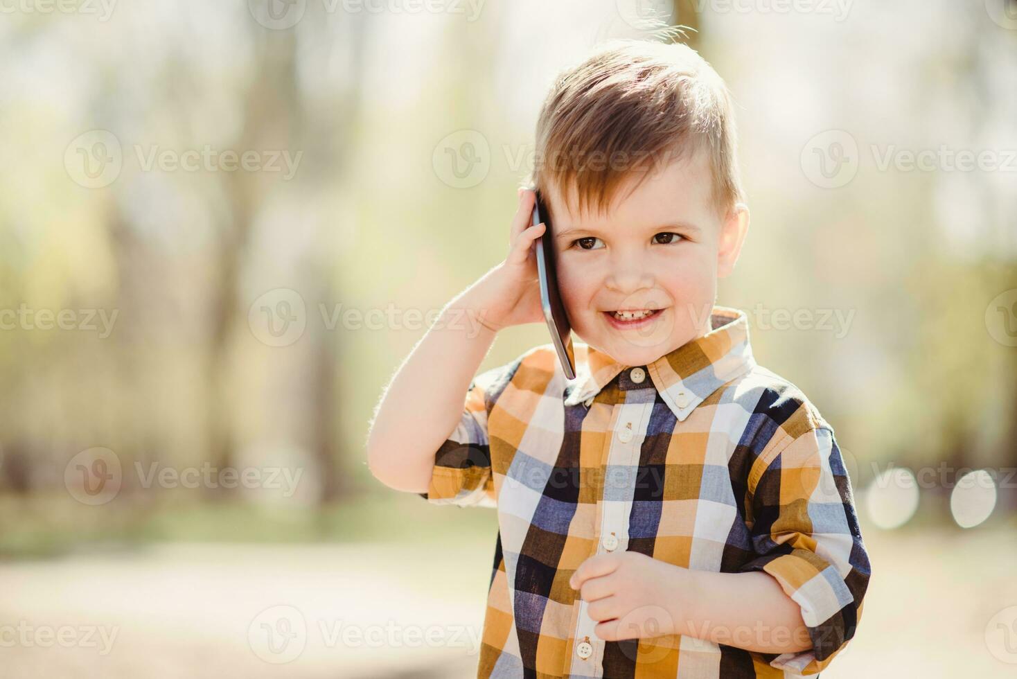 pequeño bebé es hablando en el teléfono en el calle foto