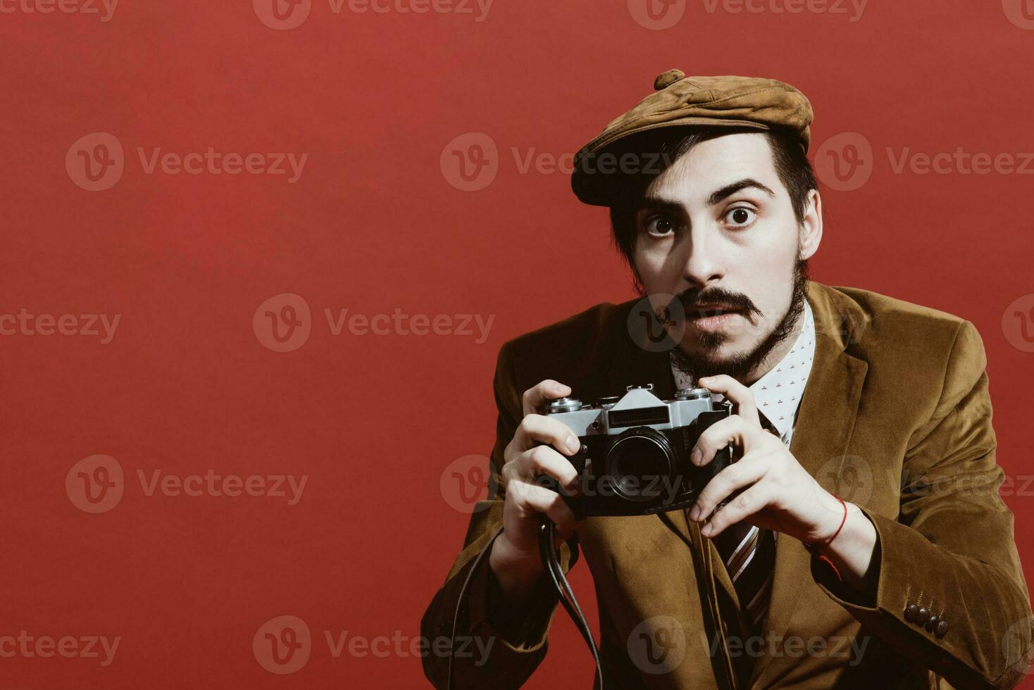 very positive photographer posing in studio with film camera photo