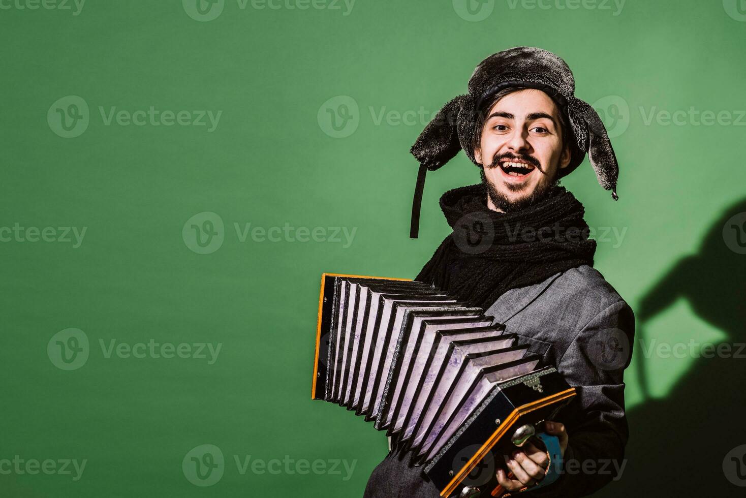 un muy positivo hombre con un acordeón posando en el estudio foto