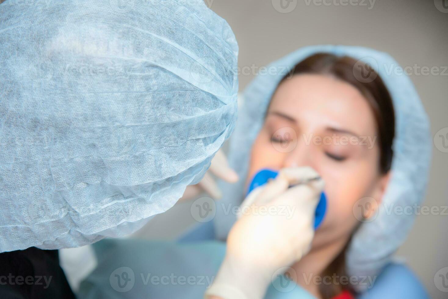 Preparing the oral cavity for whitening with an ultraviolet lamp. Close-up photo