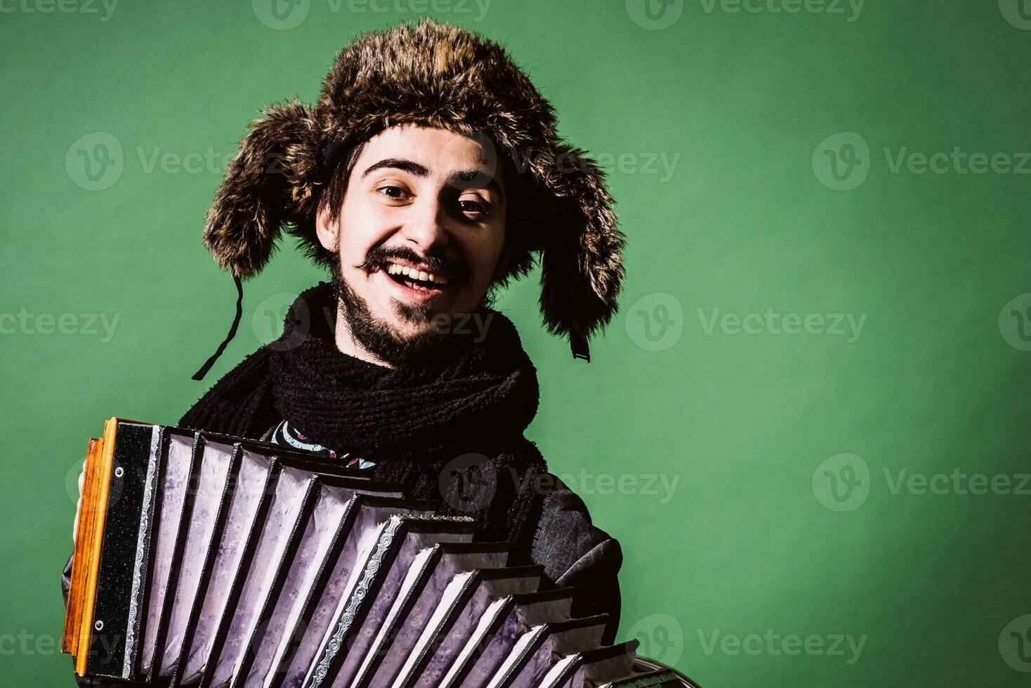 un muy positivo hombre con un acordeón posando en el estudio foto