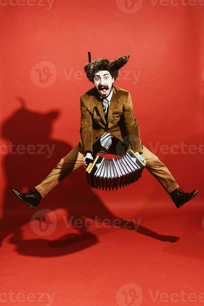 un muy positivo hombre con un acordeón posando en el estudio foto