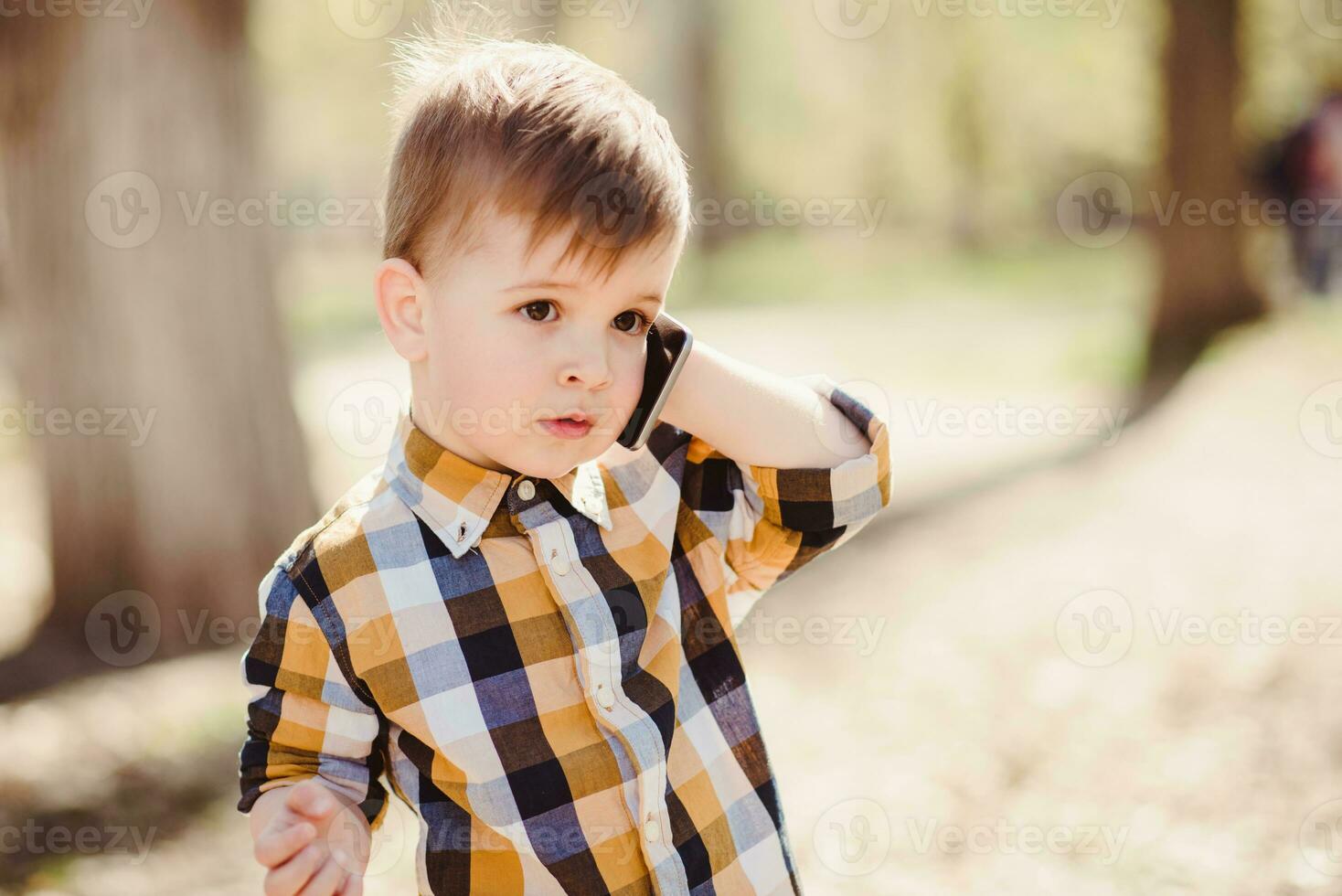 pequeño bebé es hablando en el teléfono en el calle foto