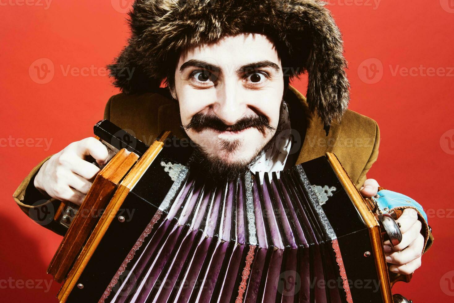 un muy positivo hombre con un acordeón posando en el estudio foto