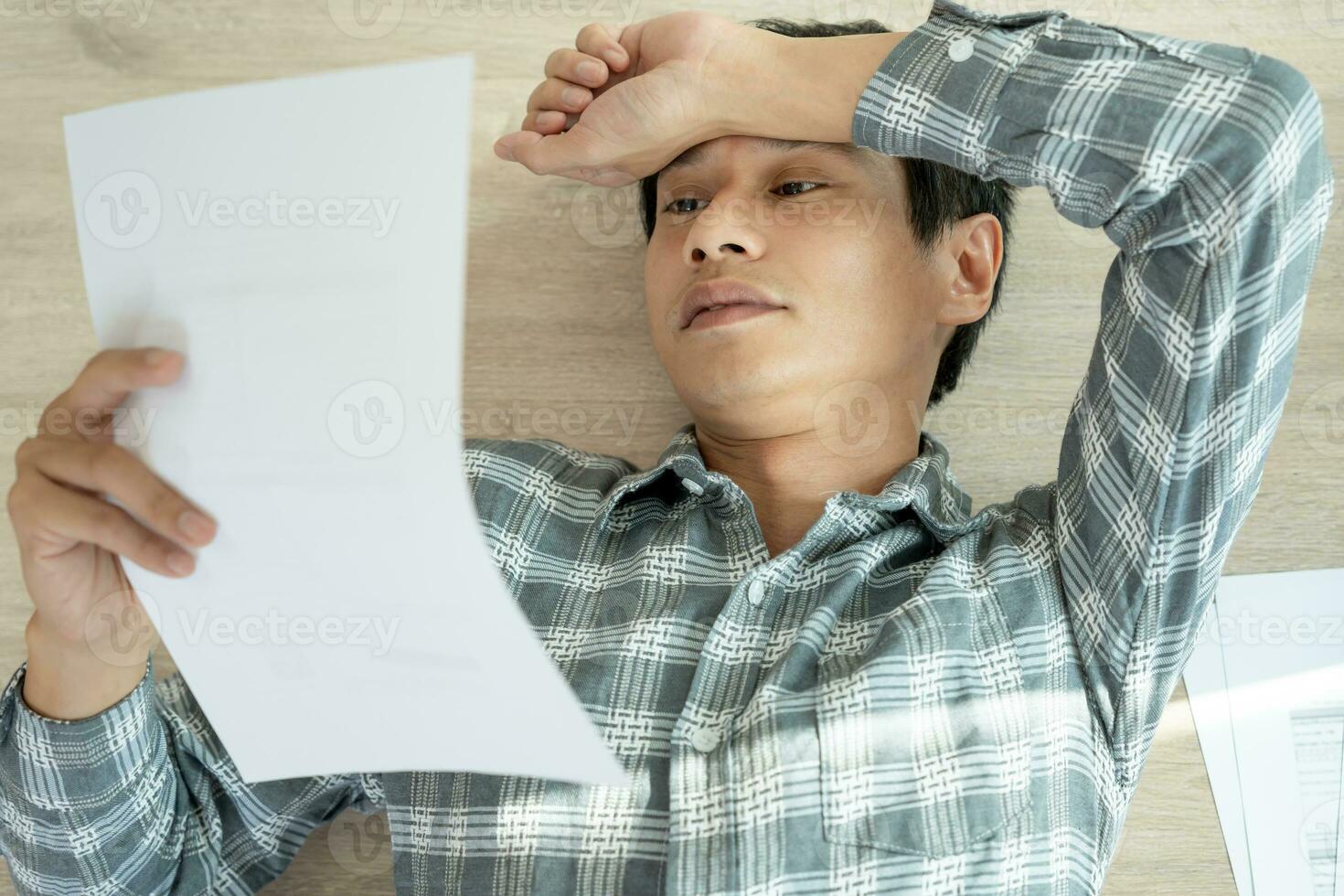 Stressed and headache asian man with large bills or invoices no money to pay to expenses and credit card debt. shortage, Financial problems, mortgage, loan, bankruptcy, bankrupt, poor, empty wallet photo