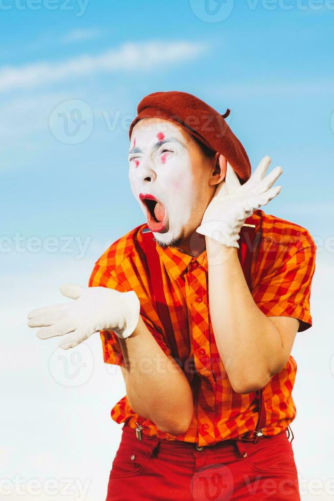 Mime shows pantomime against the blue sky photo