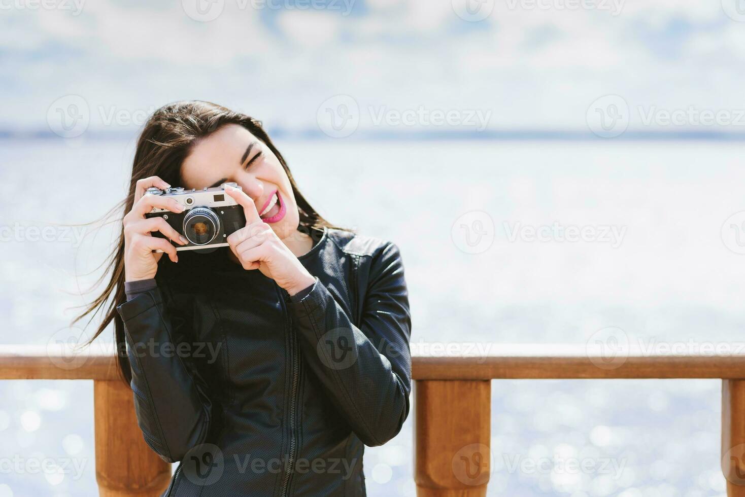 atractivo niña toma imágenes con un antiguo cámara foto