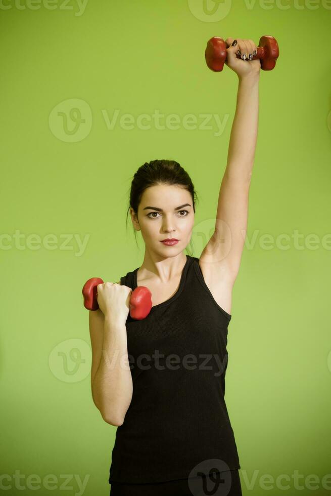 hermosa niña haciendo ejercicio con rojo pesas foto