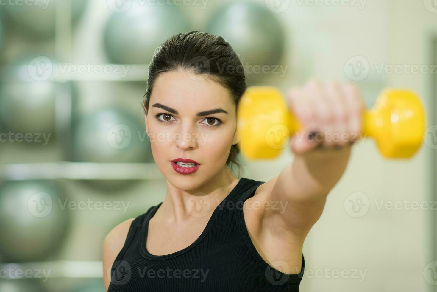 beautiful girl doing exercise with yellow dumbbell photo