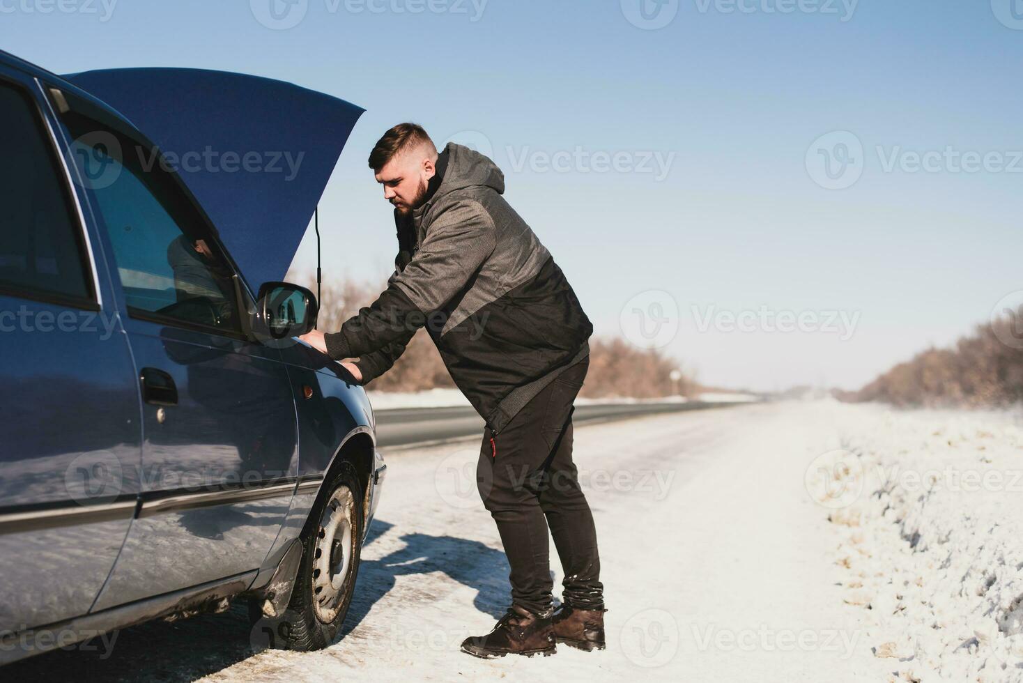 hombre reparando un coche en pie a el capucha foto